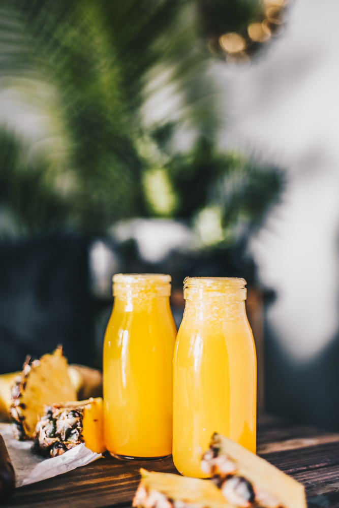Pineapple Lemon Ginger Juice with palm trees and fresh pineapple photography