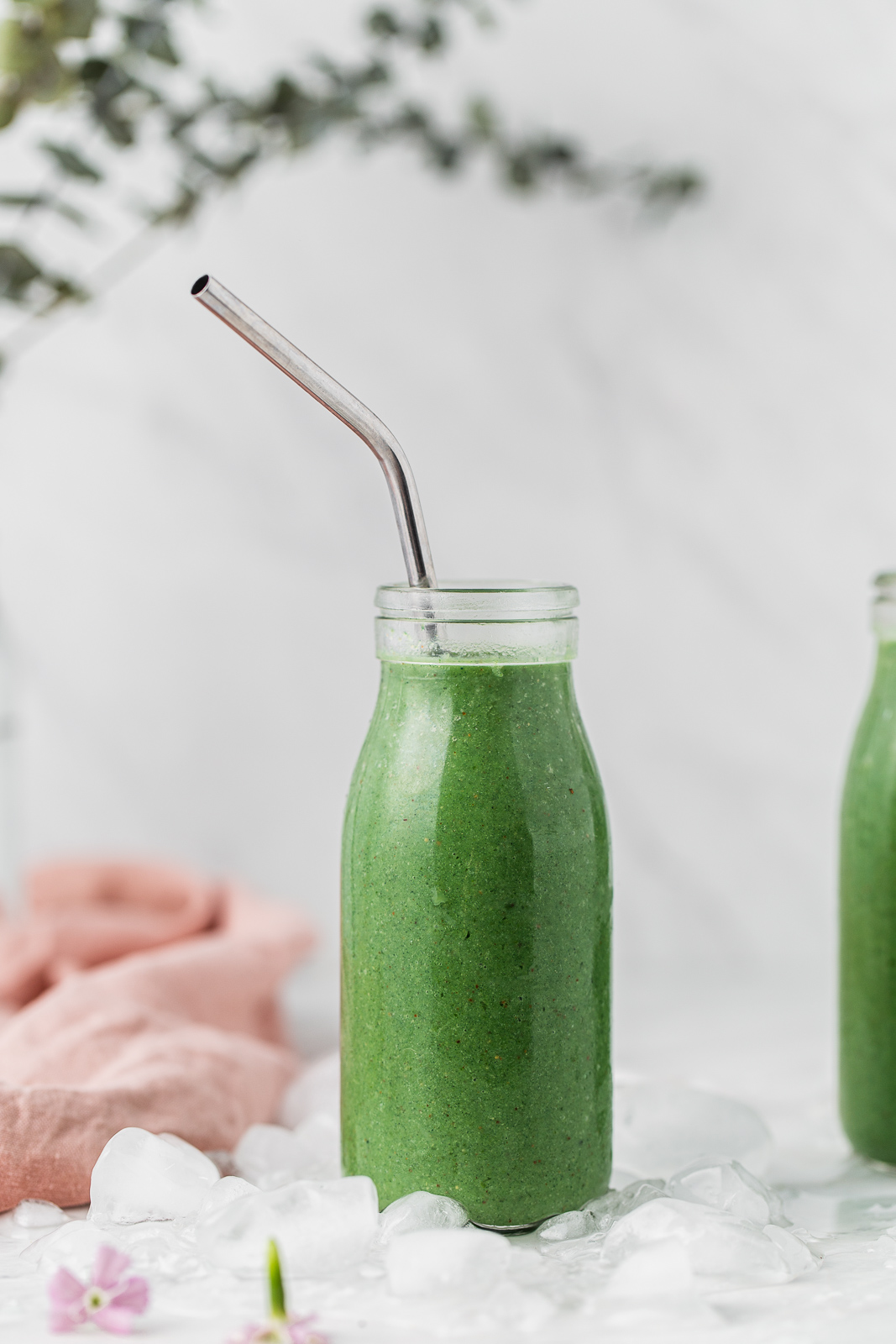 green smoothie in a glass with a straw photography