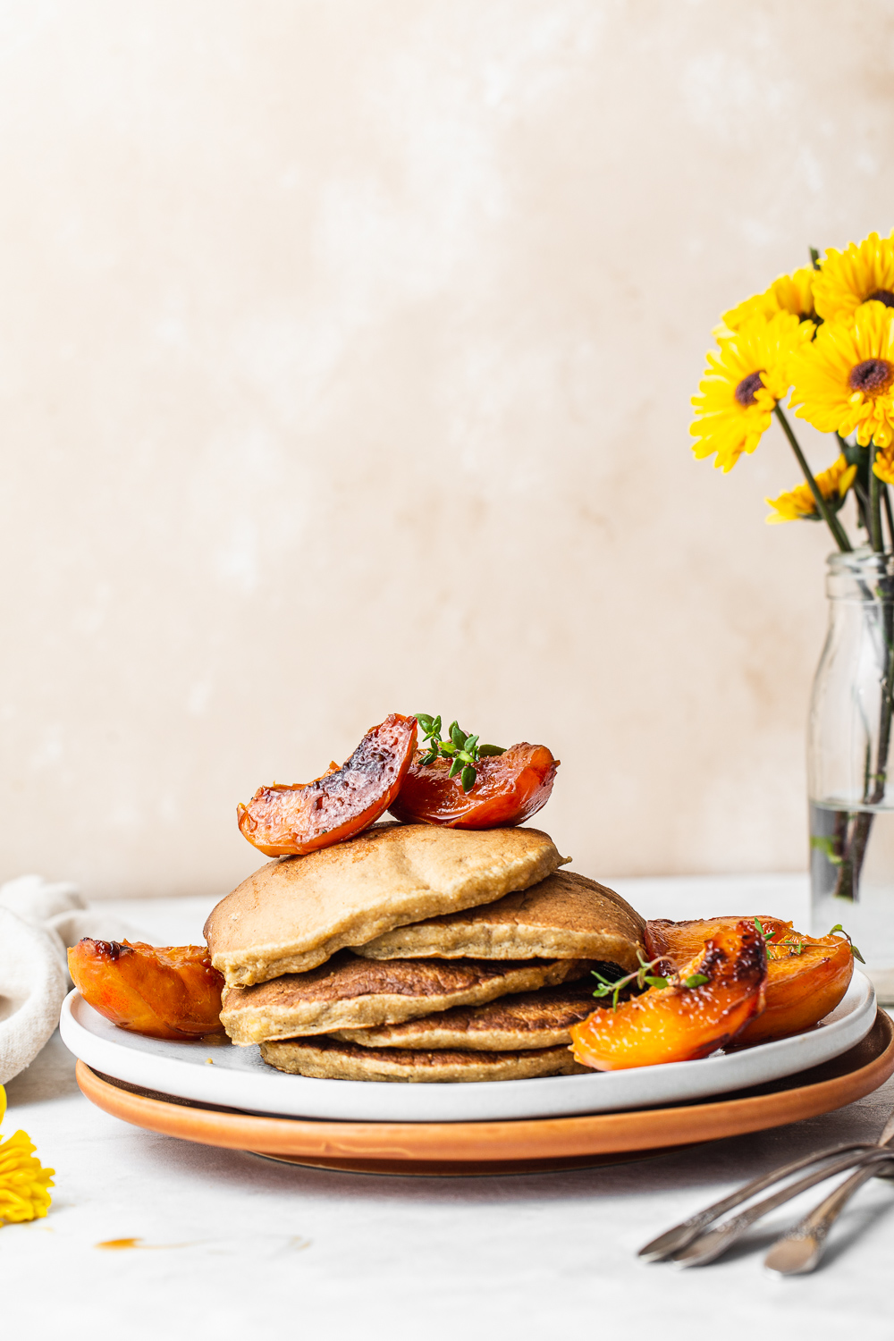 stack of pancakes with peaches and maple syrup photography