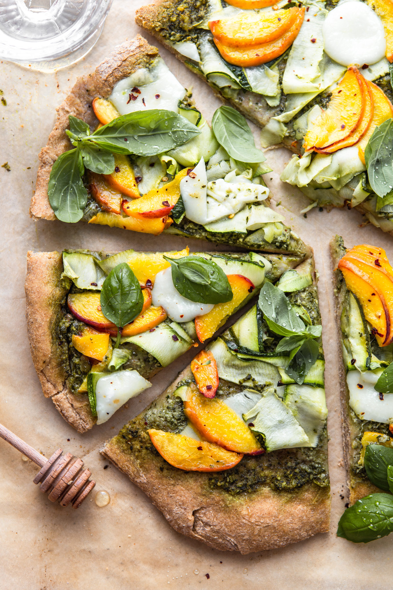 slices of pizza with peaches zucchini and pesto photography