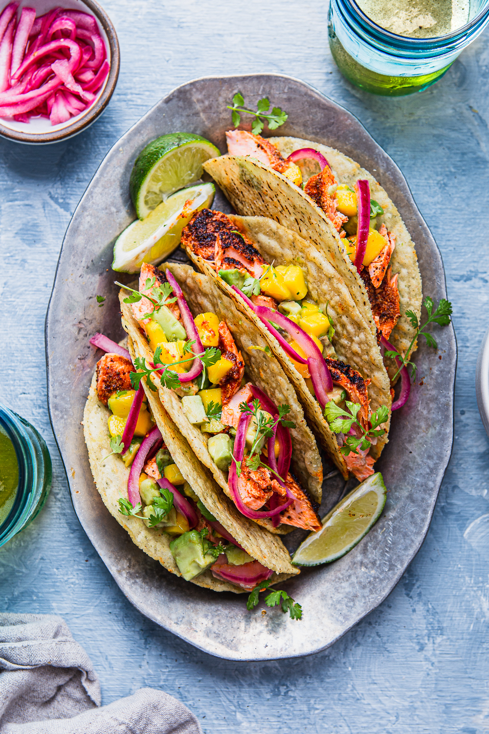 fish tacos with avocado and mango salsa pickled onions on a tray photography
