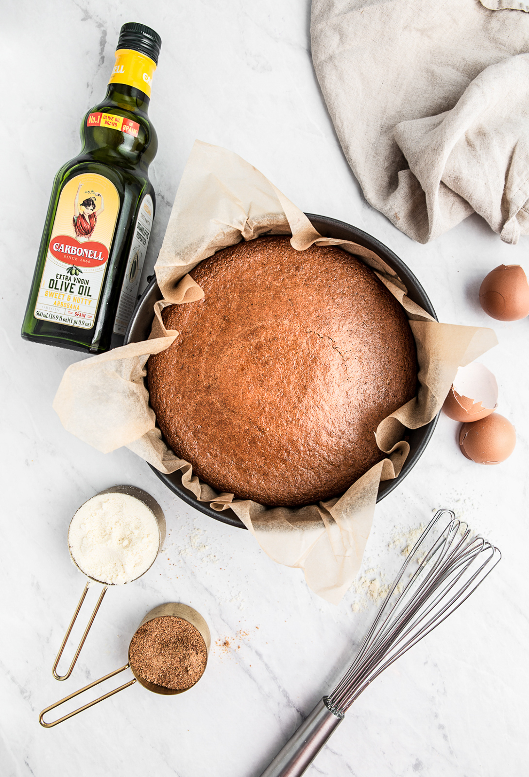olive oil lemon cake in a pan with flour sugar and eggs around