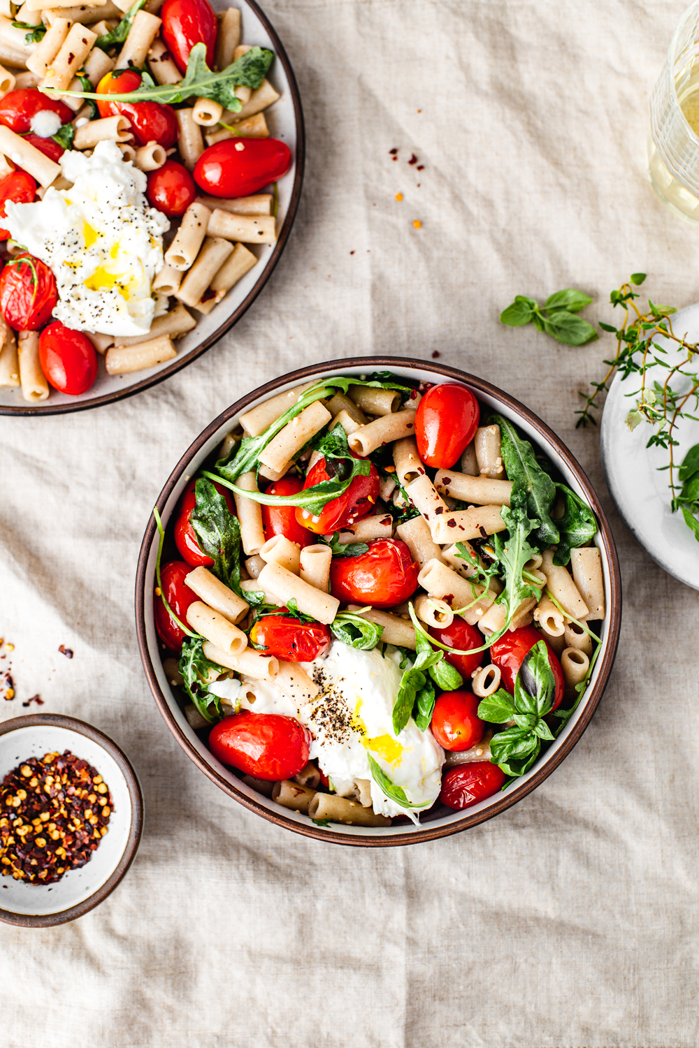 healthy pasta bowl with cherry tomatoes arugula basil and burrata cheese