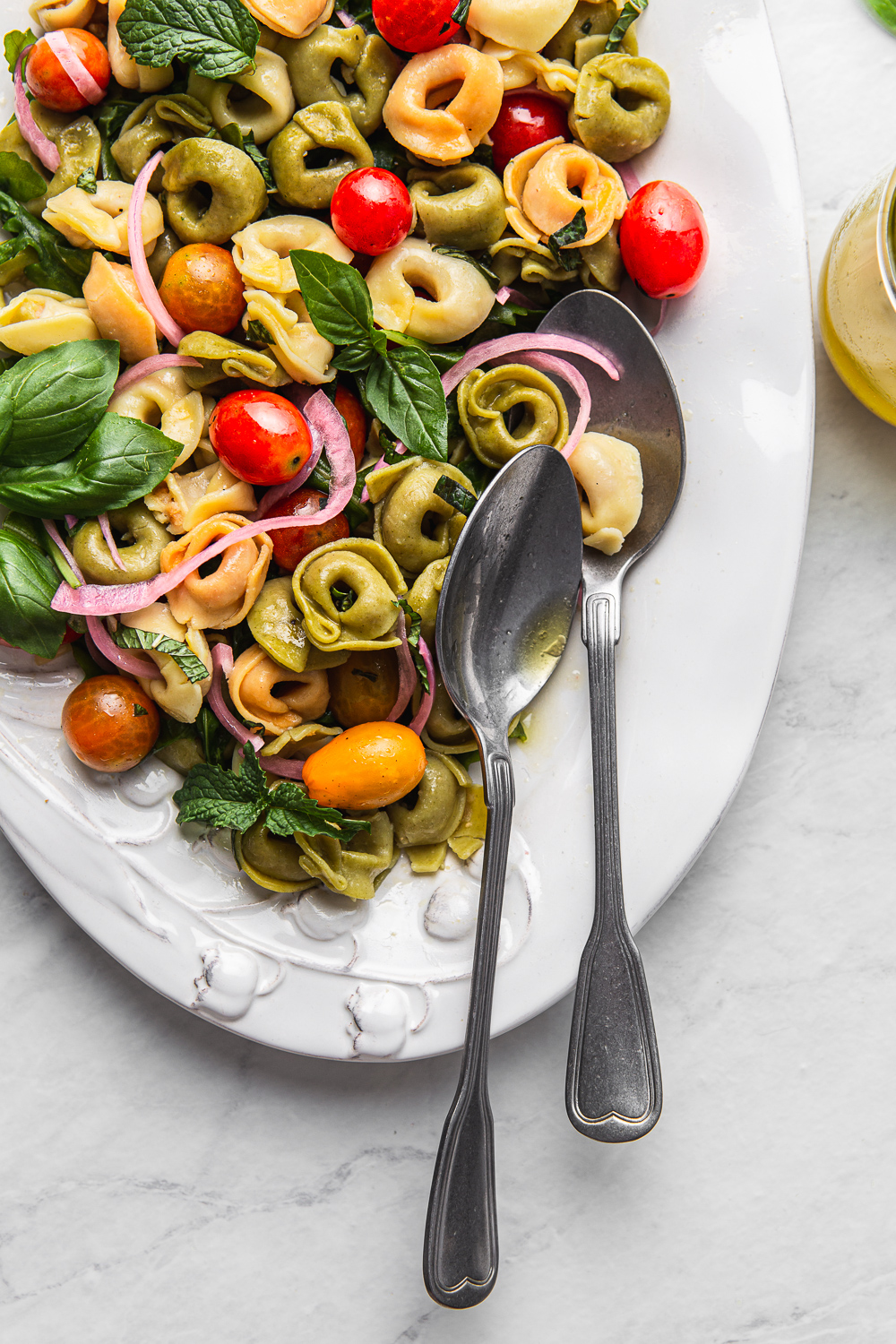 tortellini pasta with cherry tomatoes, basil and pickled onion 