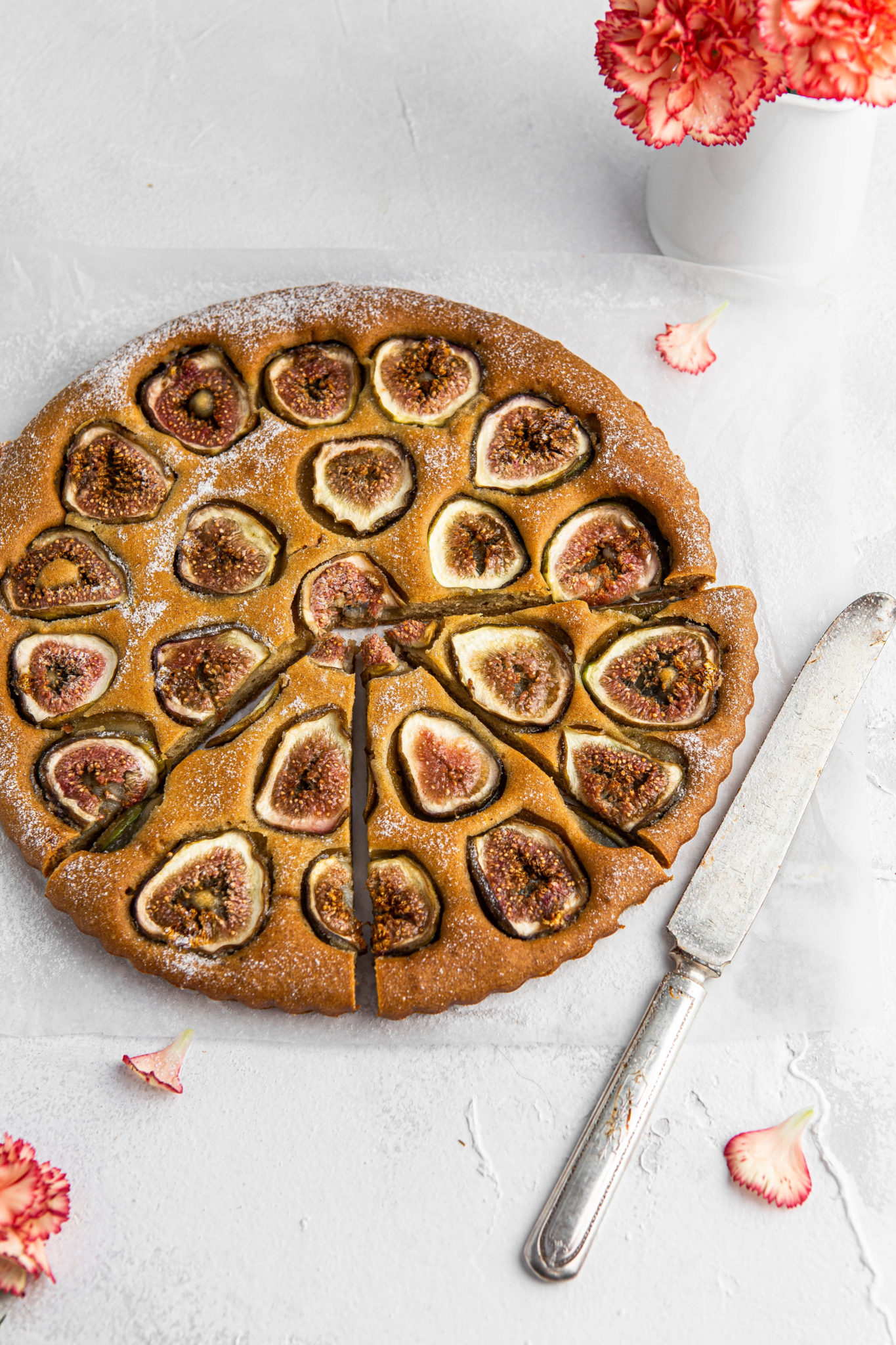 sliced fig cake with powered sugar and butter knife photography