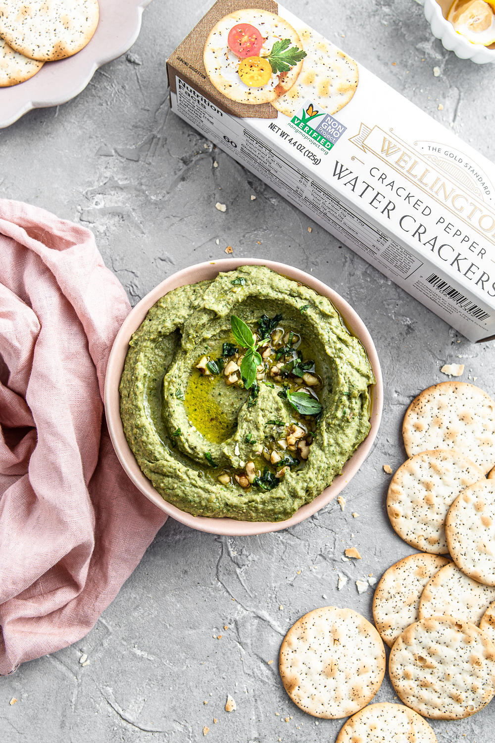 kale dip in a bowl with crackers