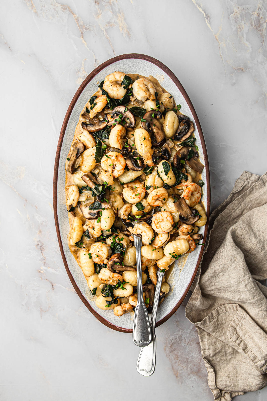 gnocchi with shrimp and mushroom in oval dish photography