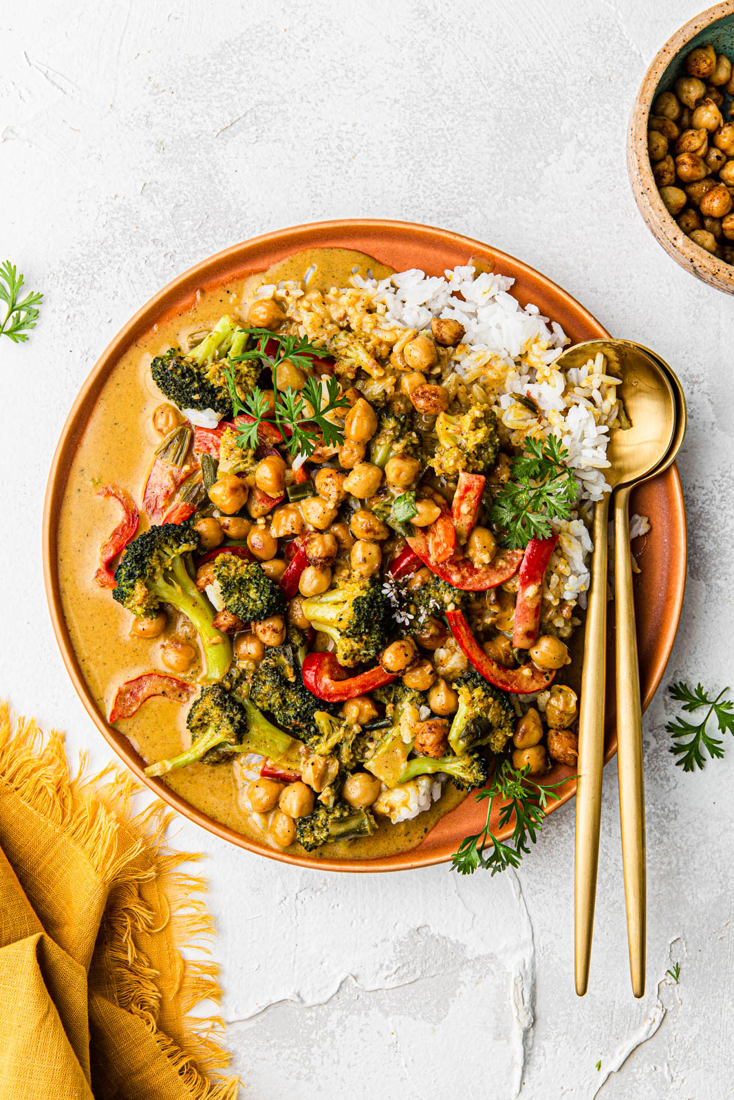 Vegan Thai Yellow Curry with Chickpeas and vegetables with gold utensils food photography