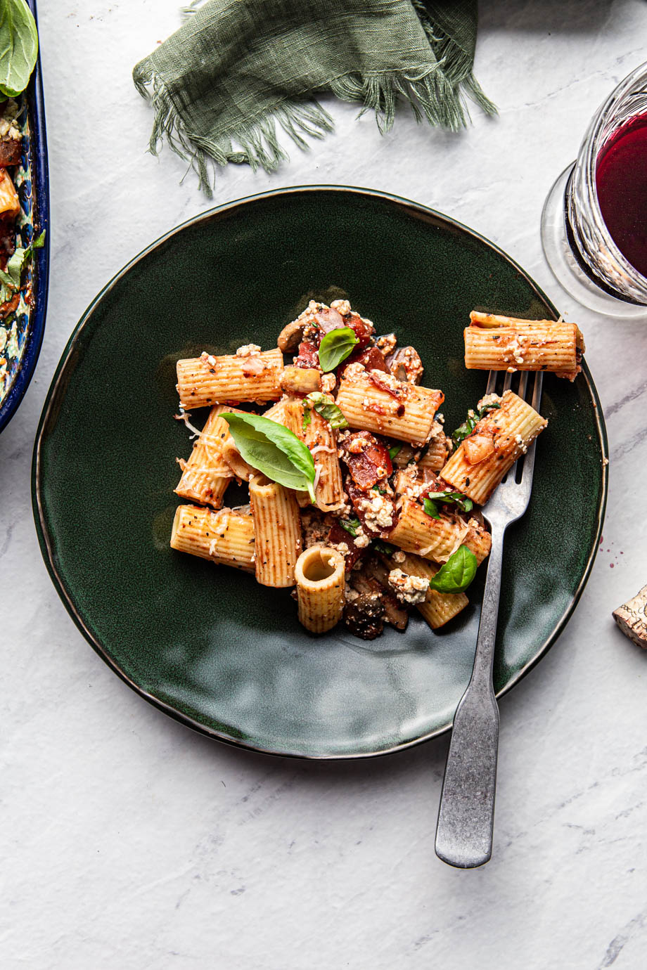 rigatoni ziti pasta on a green plate with a fork photography
