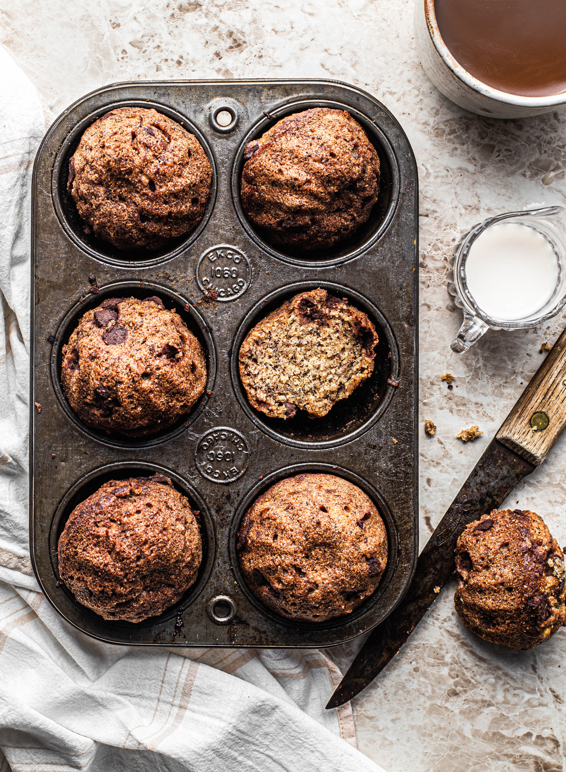 Chocolate Chip Muffins in a vintage muffin pan food photography with coffee and milk