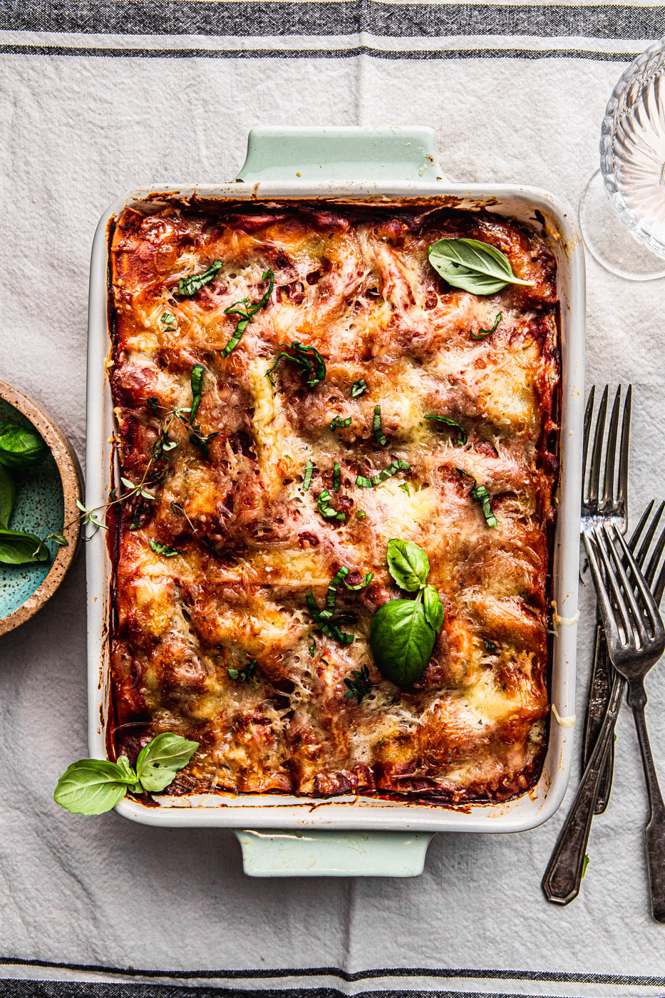 HEALTHY VEGETABLE LASAGNA in a baking dish WITH GOAT CHEESE PESTO and fresh basil food photography food styling