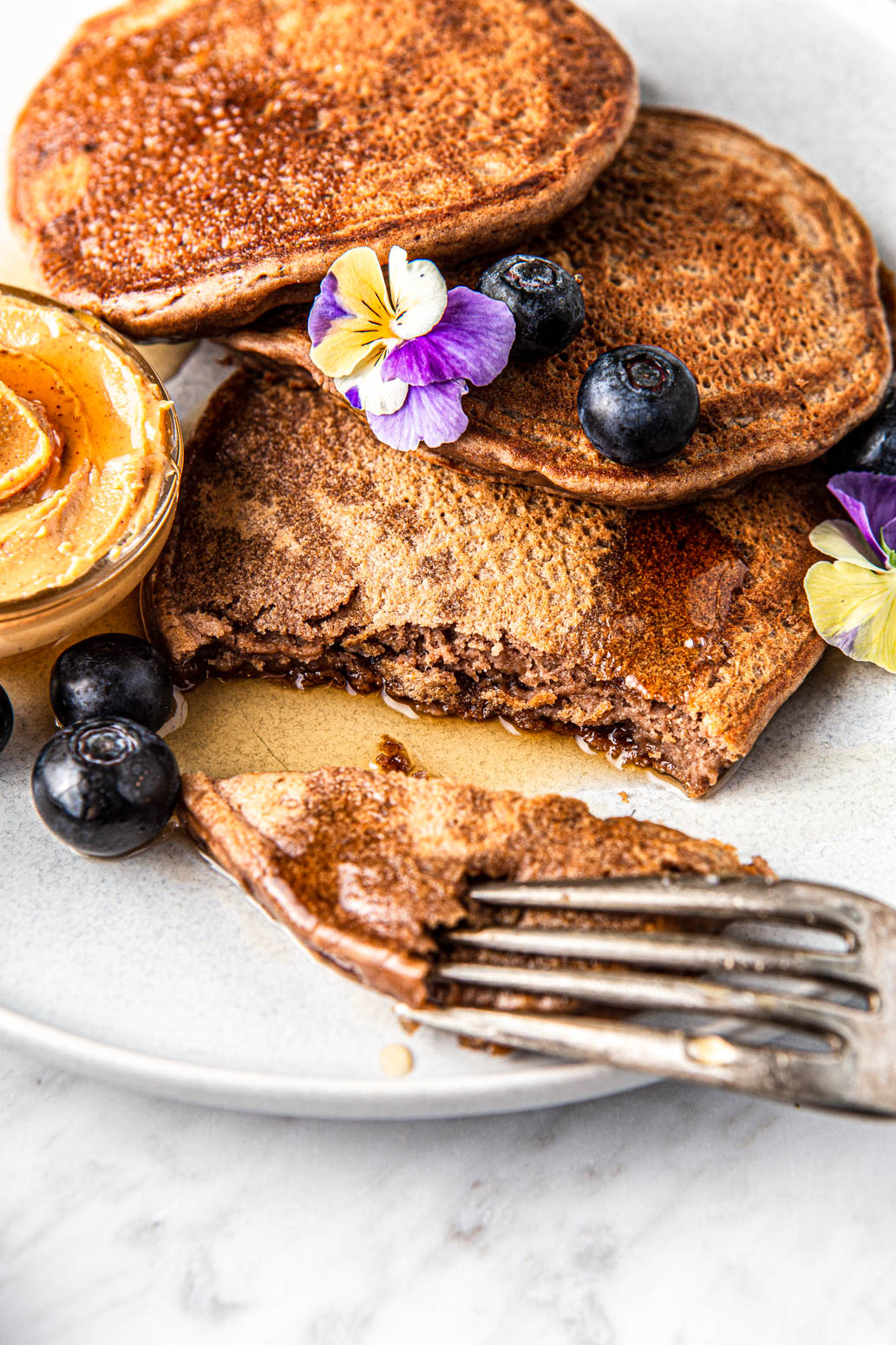 fluffy vegan chocolate peanut butter pancakes with a bite taken out photography