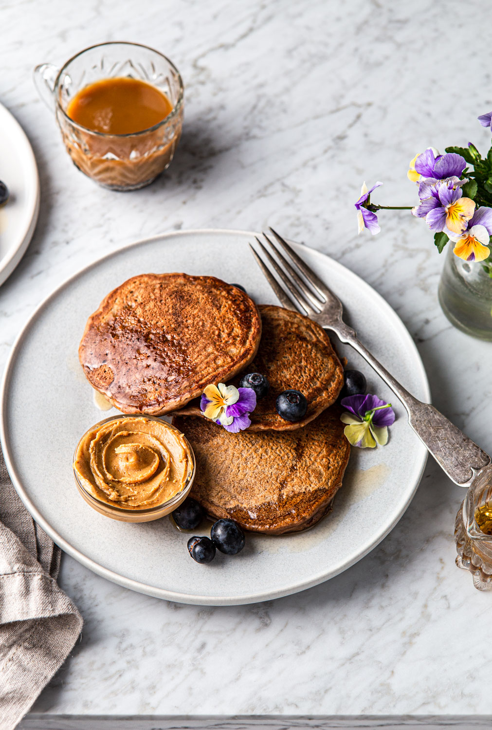 Vegan peanut butter and chocolate Protein Pancakes with flowers photography